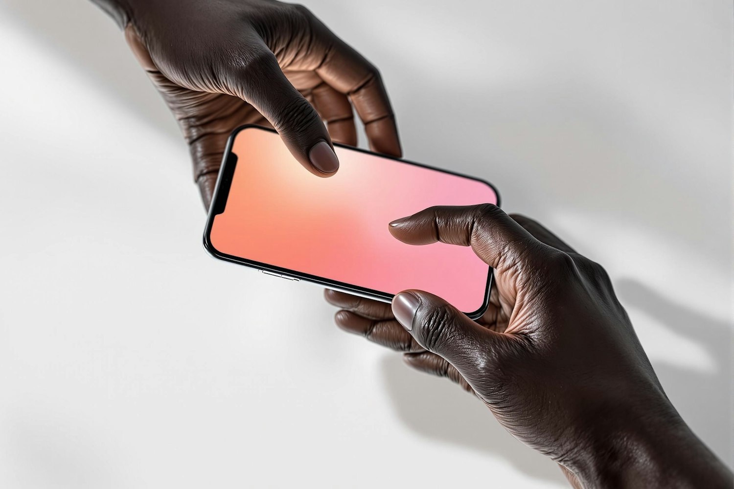 Two hands passing a smartphone with a glowing pink and peach gradient screen